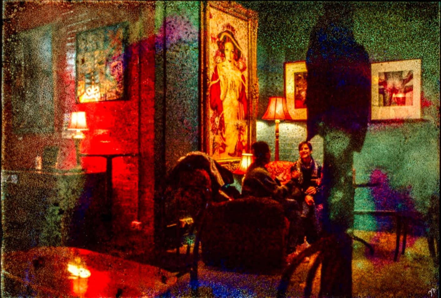 Matteo Volpi Photography Art ~ 'Friends at Dinner' - Available in Australia @ Curate Art & Design, a must-visit art gallery in Daylesford, Victoria.
People sitting in a dimly lit room with colorful lighting and artwork on the walls.