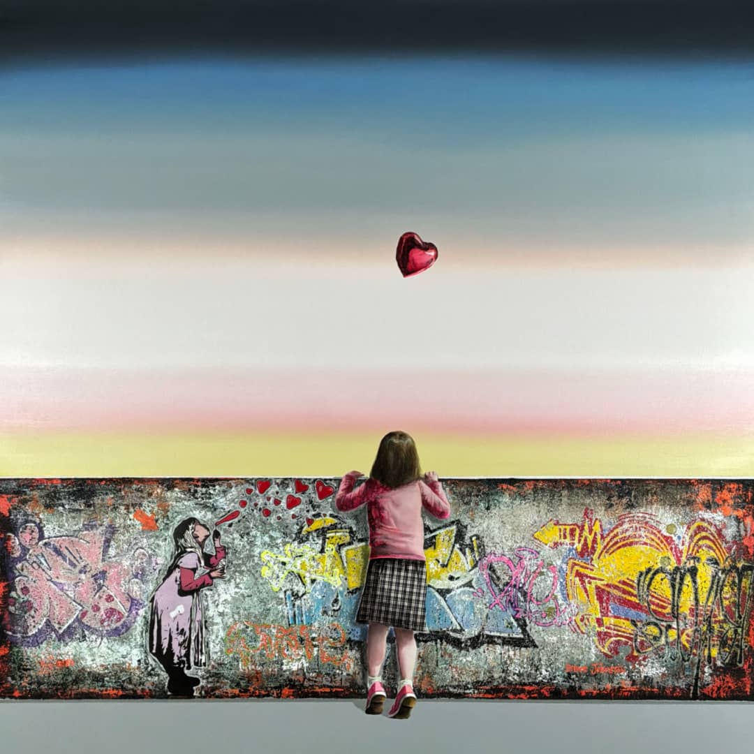 UK artist Steve Johnston painting ~ 'Blowin' in the Wind' - exclusively in Australia at Curate Art & Design in Daylesford, Melbourne, Australia.

A child stands in front of a graffiti-covered wall, facing a large canvas painting of a woman with a red heart floating above her, set against a sunset sky gradient.