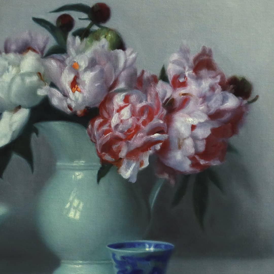 Vicki Sullivan (Archibald Prize Finalist 2026) painting ~ 'Peonies in French Jug' @ Curate Art & Design in Daylesford, Victoria (formerly Sorrento).

A still life painting featuring a bouquet of pink, red, and white peonies in a pale green vase, alongside a light green bowl, a small blue-and-white cup, and a blue decorative bottle against a muted gray background.